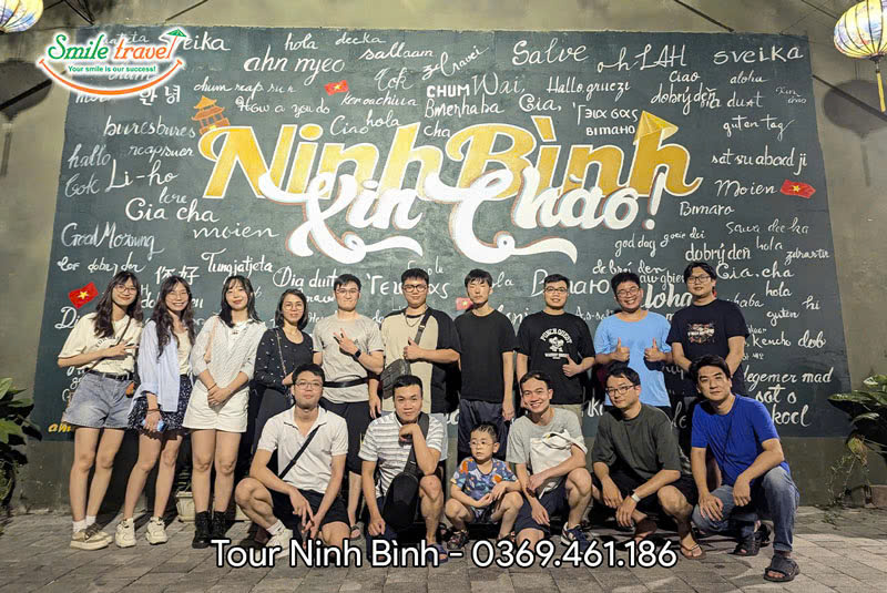 Đoàn khách đi tour Ninh Bình của Smile Travel check in "bức tường xin chào" nổi tiếng