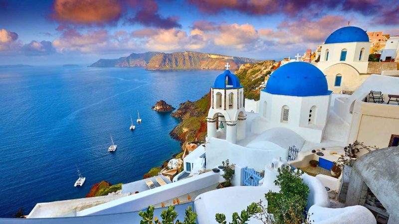 Check-in Santorini với những ngôi nhà trắng và mái vòm xanh đặc trưng.